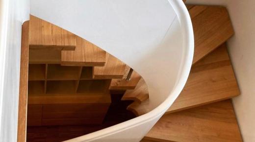 Holztreppe mit geschwungenem Handlauf in weiß