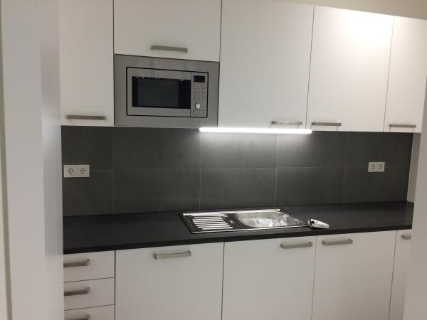 Weiße Küchenzeile mit dunkler Rückwand