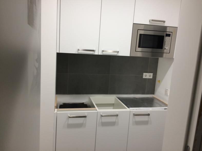 Weiße Küchenzeile mit dunkler Rückwand