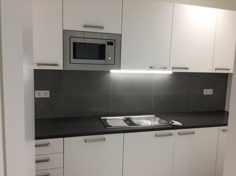 Weiße Küchenzeile mit dunkler Rückwand