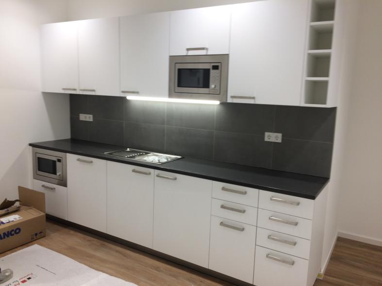 Weiße Küchenzeile mit dunkler Rückwand